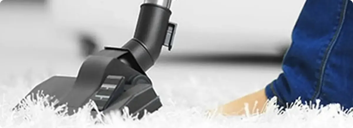 Close-up of a professional vacuuming a white carpet in Davey.